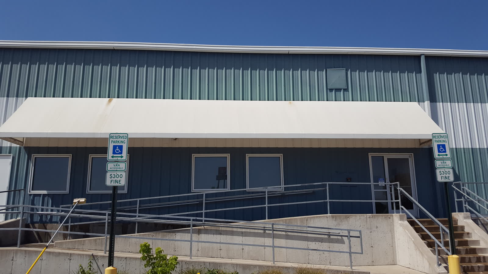 Metal-clad commercial building in St. Louis County with a painted entry canopy, steel siding and concrete steps