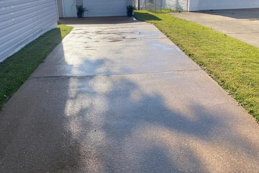 Freshly cleaned concrete driveway running to a detached garage at a St. Louis County home